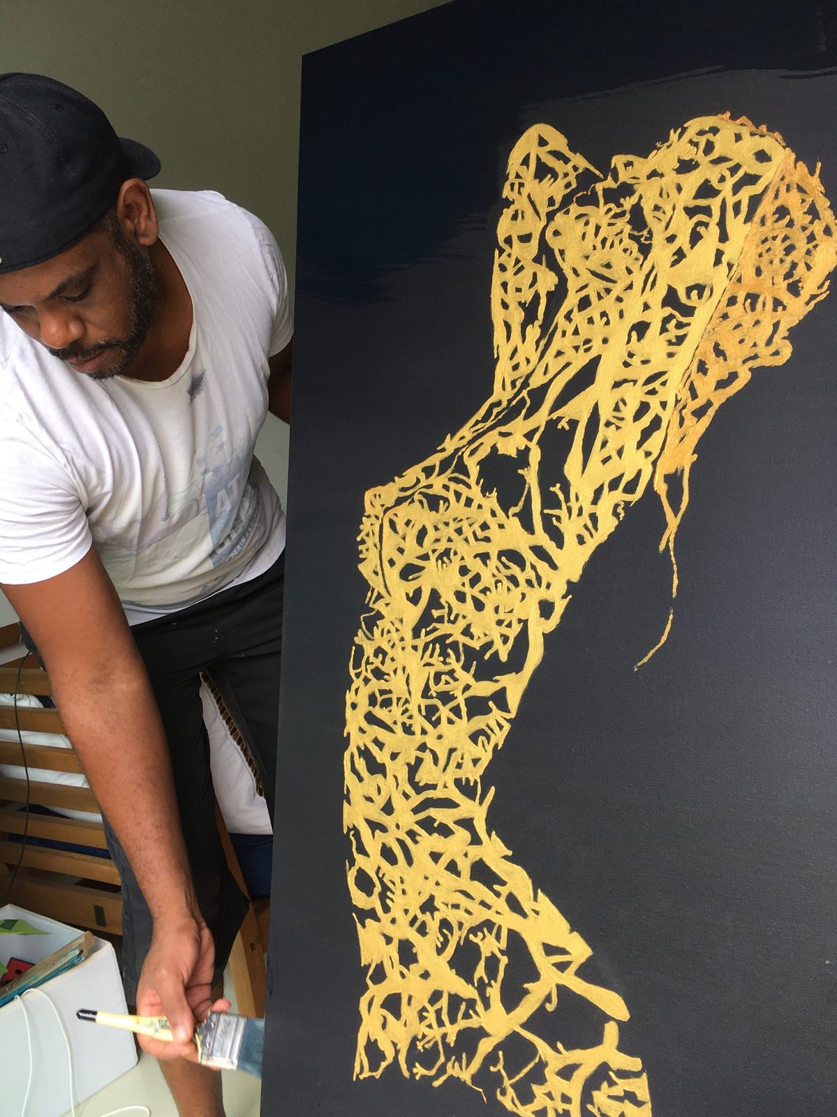 Raúl painting a golden figure in Havana