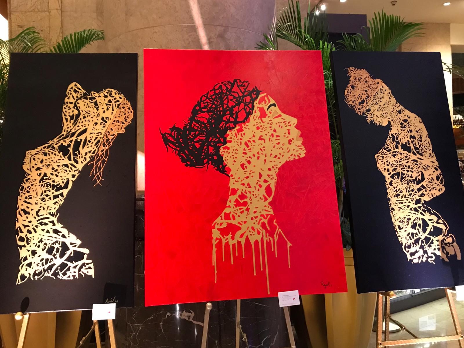 Three golden line paintings on easels at The Fullerton Hotel