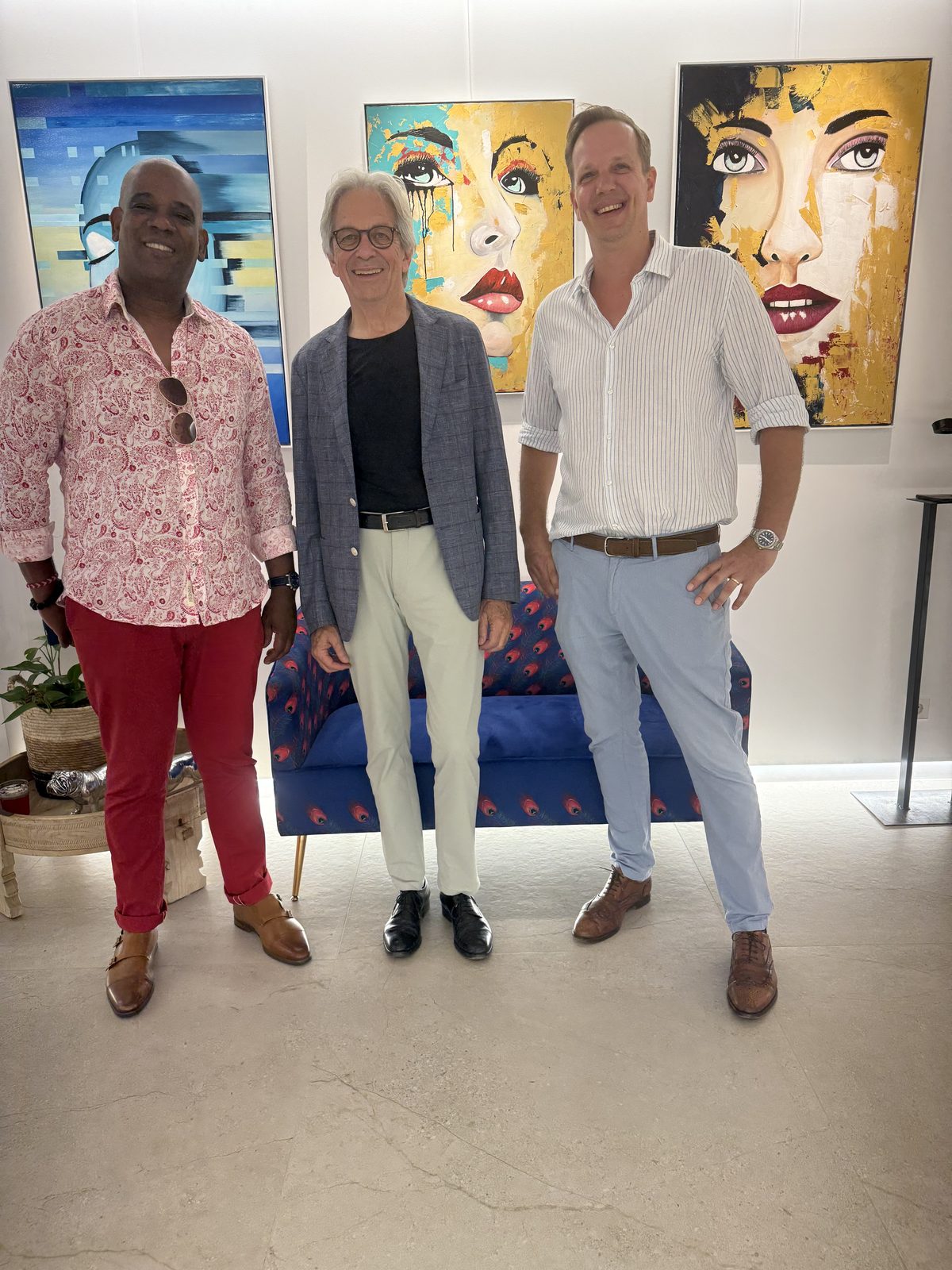 Raúl with two guests in front of colorful portraits at Studio Gallery Mallorca